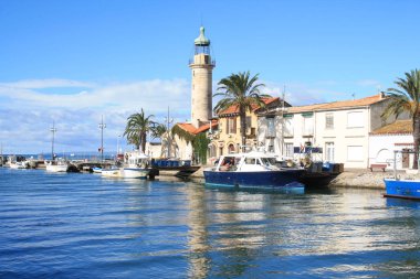 Deniz feneri ve Fransa 'nın Occitanie bölgesinde bir tatil beldesi olan Camargue' deki Grau du Roi 'nin eski balıkçılık limanı.