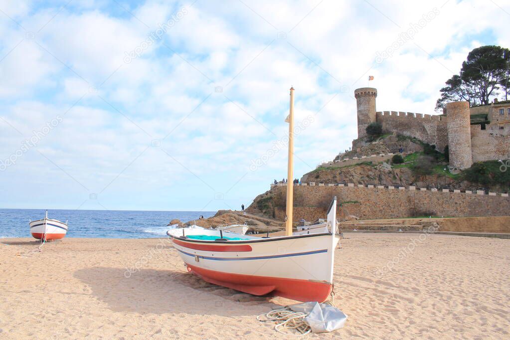 Traditional fishing boats on the beach of Tossa de Mar, a charming historic town constructed around a magnificent ancient castle, located in the Spanish region of Catalonia on the Costa Brava