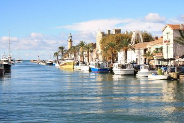 Deniz feneri ve Fransa 'nın Occitanie bölgesinde bir tatil beldesi olan Camargue' deki Grau du Roi 'nin eski balıkçılık limanı.