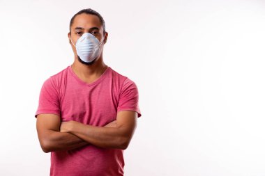 Maskeli ve kolları bağlı genç Latin bir adam. Coronavirus Konsepti.