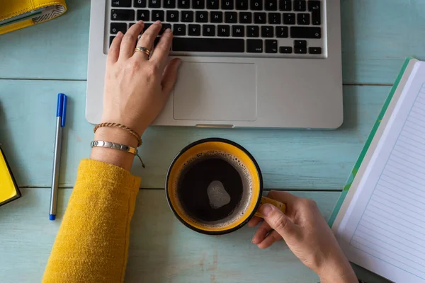 Çalışan ve kahve içen bir kadının yukarıdan görünüşü. Ev konseptinde çalış