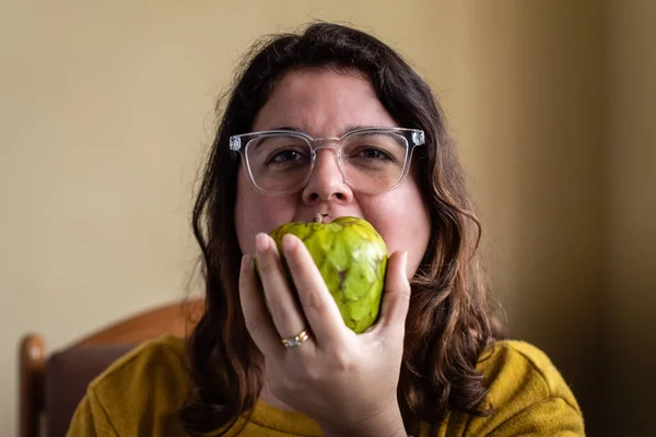 Girl bites into a custard apple