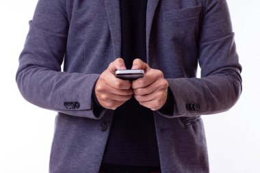 Beyaz arka planda akıllı telefonunu kullanan Latin bir işadamının yakın plan fotoğrafı..