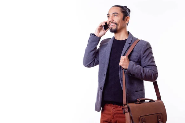 Latin işadamı beyaz arka planda akıllı telefonuyla arama yapıyor. Boşluğu kopyala