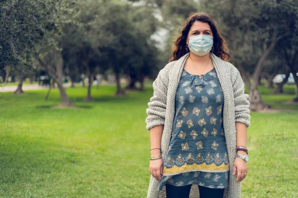 Genç bir kadın virüsten korunmak için koruyucu bir maske takıyor. Coronavirus konsepti.