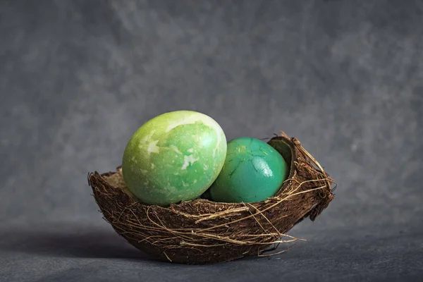 Easter eggs in a coconut shell. Eggs on a grey background. Coffee beans around