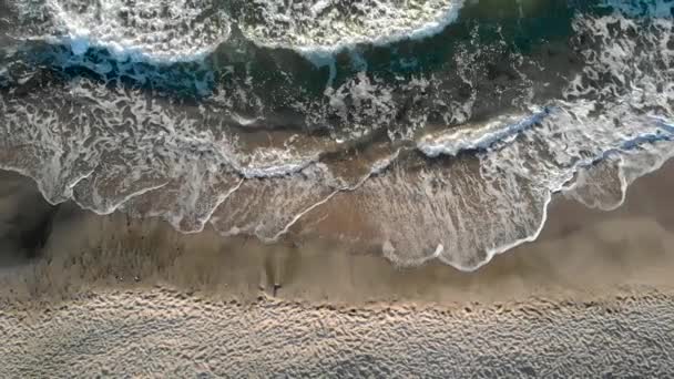 Images aériennes de drones montrant des vagues qui s'écrasent et le coucher du soleil frappant la plage à Sinemorets Bulgarie .
