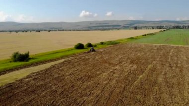 Günbatımı alan üzücü traktör yukarıda havadan görünümü.