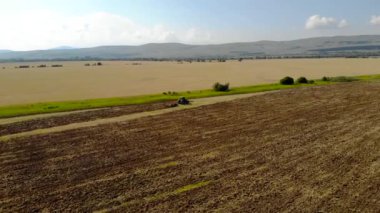 Günbatımı alan üzücü traktör yukarıda havadan görünümü.