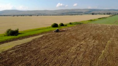 Günbatımı alan üzücü traktör yukarıda havadan görünümü.