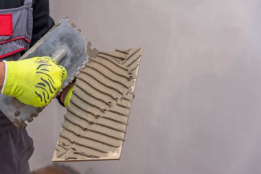 Seramik fayanslar ve tiler için aletler. Döşeme döşemesi. Ev tadilatı, yenileme - seramik fayans döşeme tutkalı, havan topu, seviye.