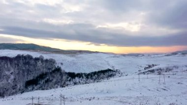 Kışın kar üzerinde altın bir gündoğumu havadan görünümü.