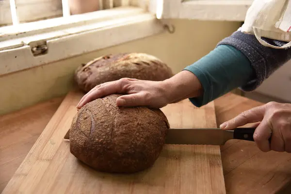 Cortar la barra de pan en rodajas. Pan casero — Foto de Stock
