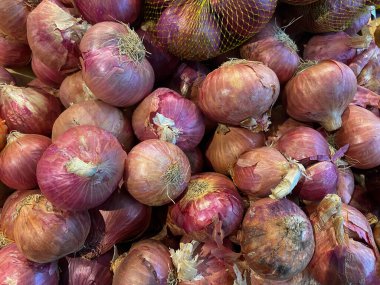 Arpacık soğanı arkaplanı ve dokusu. Taze pazarda soğan yığını. Yiyecek malzemesi için bulanıklık.