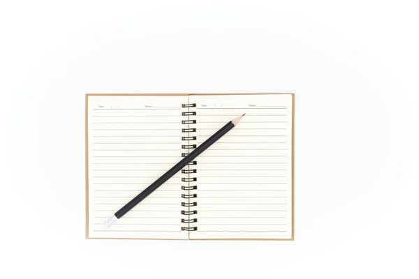 鉛筆はノートブック内の傾斜した位置に置かれます 白地に置かれてる — ストック写真