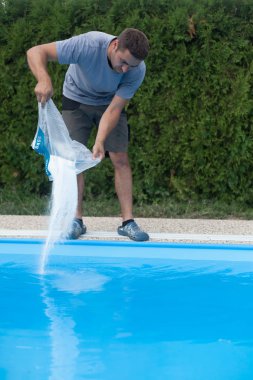 Adam ev havuzundaki deniz tuzunu tamamlıyor..