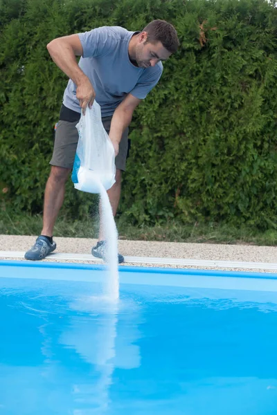 Adam ev havuzundaki deniz tuzunu tamamlıyor..