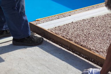 İşçi, taştan bir halı ve reçine koyar.