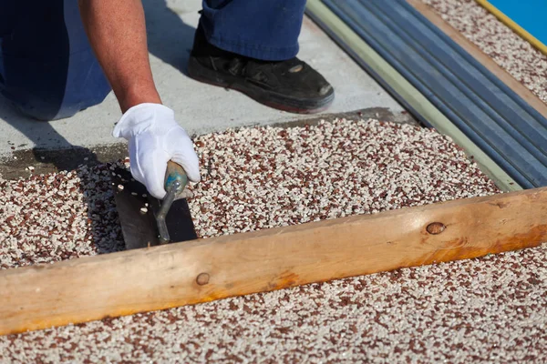 İşçi, taştan bir halı ve reçine koyar.