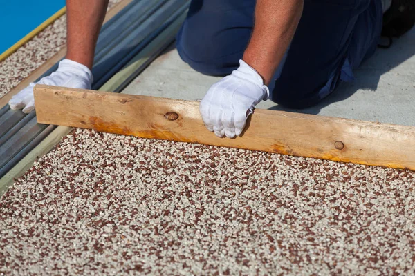 İşçi, taştan bir halı ve reçine koyar.