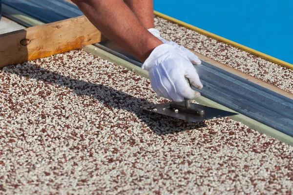 İşçi, taştan bir halı ve reçine koyar.