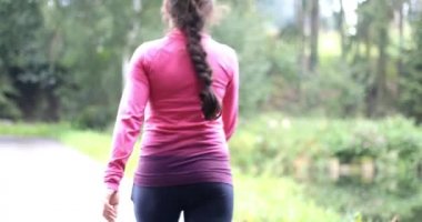 Ormanda yürüyüşe katılan genç kadın. Hızlı yürüyüş. Kız sağlık yaşam tarzı itiraf ediyor. Sığ Dof.