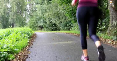 Ormanda yürüyüşe katılan genç kadın. Hızlı yürüyüş. Kız sağlık yaşam tarzı itiraf ediyor. Sığ Dof.