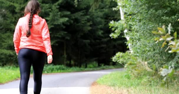 森の中を散歩している若い女性 クイックウォーク 女の子は健康的なライフスタイルを公言しています 浅いドーフ — ストック動画