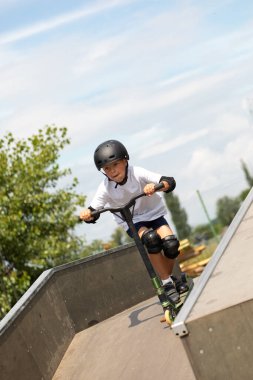 Çocuk bir scooter 'a atlıyor.
