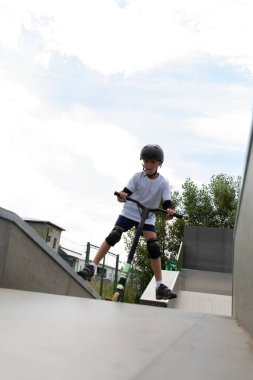 Çocuk bir scooter 'a atlıyor.