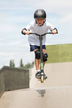 Çocuk bir scooter 'a atlıyor.