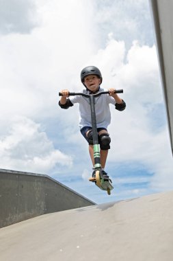 Çocuk bir scooter 'a atlıyor.