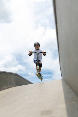 Çocuk bir scooter 'a atlıyor.