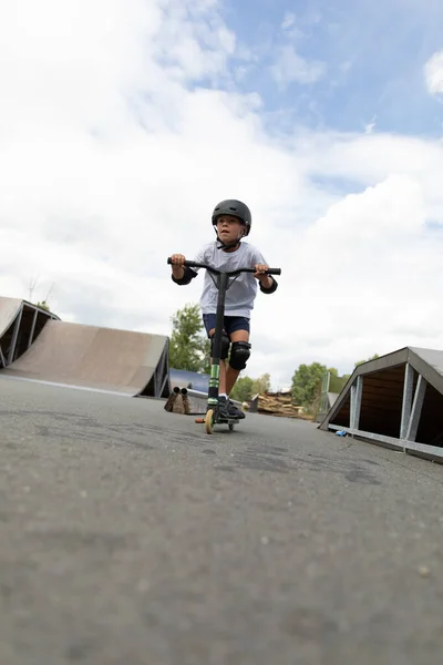 Ένα Χαριτωμένο Μικρό Αγόρι Οδηγεί Ένα Σκούτερ Ένα Skatepark Ένας — Φωτογραφία Αρχείου