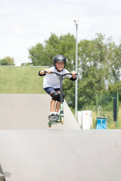 Ein Süßer Kleiner Junge Fährt Auf Einem Roller Einem Skatepark — Stockfoto