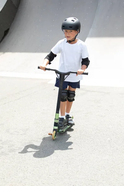 Cute Little Boy Rides Scooter Skatepark Young Novice Athlete Spends — Stock Photo, Image