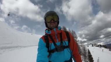 Genç adam kayak yapmaktan hoşlanıyor. Kayakçıların alışılmadık görüntüleri. Kayağın ucundan çekilmiştir. Sabit görüntü. Yavaş çekim.  