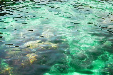 Mavi kristal berrak deniz suyu, taş dokusu arka plan, turkuaz şeffaf okyanus, sualtı mercan resifi yüzeyi yakından, güneş ışınları yansıması, yeşil su soyut doğal arkaplan