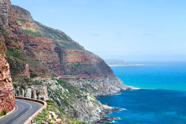 Mountain road along the sea coast, turquoise ocean water seascape, blue sky, azure sea panorama, Chapmans Peak Drive road, beautiful mountain view landscape, Cape Town, South Africa coast travel