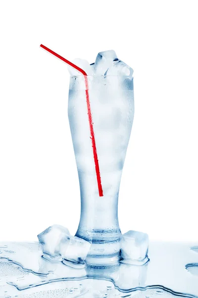 冷たいクリスタルクリア水の1つの完全な透明ガラス 赤い飲料わら 氷のキューブ 結露ドロップ 白の背景を閉じ 青の新鮮なクールなミネラルウォーターのカップ 水スプラッシュこぼした隔離された — ストック写真