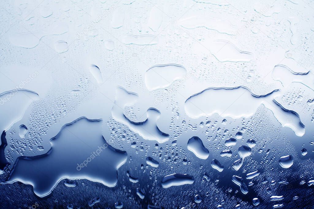 Wet glass surface in water drops, blue gradient, illustration of cool or cold water, texture of spilled water, abstract background, layout, banner, wallpaper, condensate drops on glass close up macro