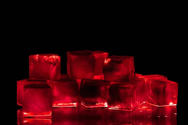 黒の背景に赤い氷のキューブを隔離された閉鎖 赤のバックライトと反射と透明な冷凍ブルゴーニュワイン色の水 抽象的な冷たいアルコール飲料のコンセプト 夜のパーティーのデザイン コピースペース — ストック写真
