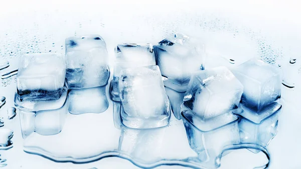 反射と白いガラスミラーの背景に氷のキューブトップビューを閉じ 透明凍結砕いた青の氷のキューブ クリア溶融流出冷たい水滴 冷たい新鮮な飲み物成分 コピースペース — ストック写真