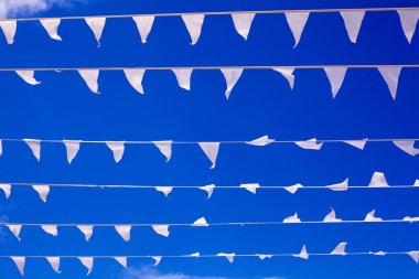 Rüzgarda dalgalanan beyaz bayraklar lacivert arka planda, rüzgarda dalgalanan pankartlar havada dalgalanıyor dekoratif çelenkler havada dalgalanıyor, güzel bayraklar dalgalanıyor, gök yüzünde dalgalanan üçgen bayraklar