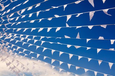 Rüzgarda dalgalanan beyaz bayraklar lacivert arka planda, rüzgarda dalgalanan pankartlar havada dalgalanıyor dekoratif çelenkler havada dalgalanıyor, güzel bayraklar dalgalanıyor, gök yüzünde dalgalanan üçgen bayraklar