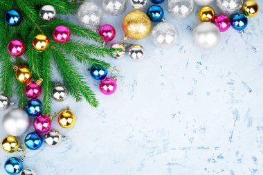 Noel kutlaması çerçevesi, yeni yıl dekoratif çerçevesi, altın, gümüş, pembe toplar süslemeler, yeşil köknar dalları, açık mavi buzlu desenli arka plan, kış tatili tebrik kartı, metin kopyalama alanı