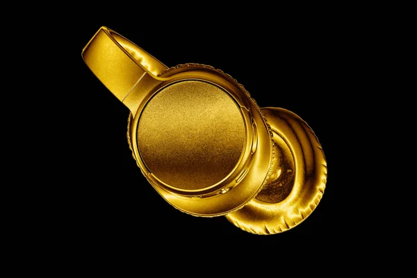 Golden shiny wireless headphones on black background isolated close up, luxury gold metal bluetooth headset, modern high end wi-fi yellow earphones, audio music symbol, stereo sound electronics sign