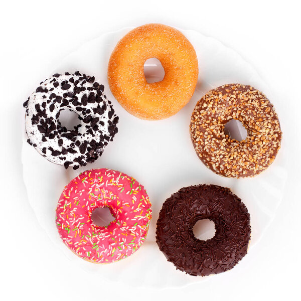 Donuts on a white plate on a white background top view
