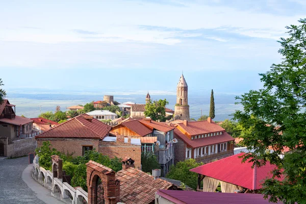 Gürcistan, Kakheti bölgesindeki Sighnaghi aşk şehri, Katedral ve kalenin kırmızı çatıları ve tuğla kuleleri, taş yol, ufuk, mavi gökyüzü ve yeşil ağaçların arka planı