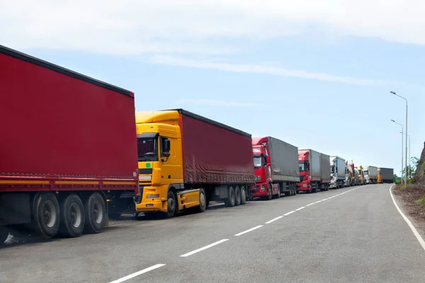 Uluslararası sınırdan geçen kamyonların kuyruğu, trafik sıkışıklığında kırmızı ve farklı renkte kamyonlar